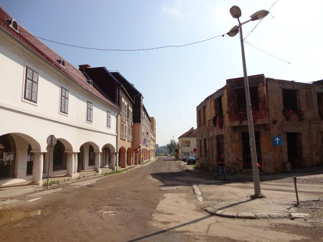 Épülő utca és a romos, muskátlis ház